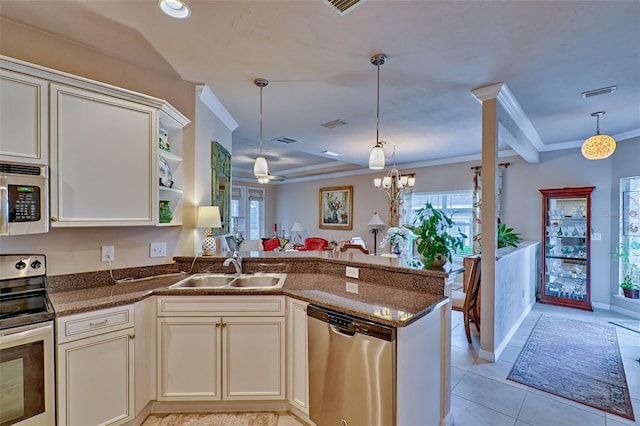 kitchen with a peninsula, ornamental molding, stainless steel appliances, and a sink