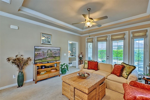 living room with light carpet, a raised ceiling, crown molding, and french doors