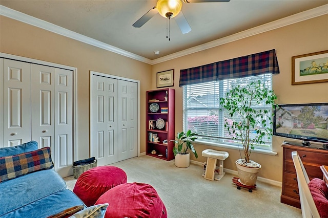 interior space featuring a ceiling fan, carpet, baseboards, and crown molding