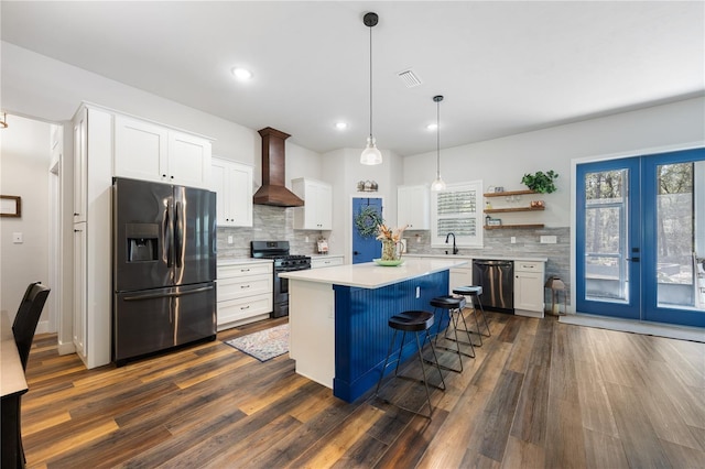 kitchen featuring dishwasher, gas range oven, fridge with ice dispenser, wall chimney range hood, and a sink