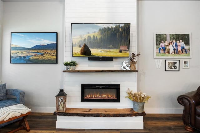 living area featuring dark wood-style flooring, a fireplace, and baseboards