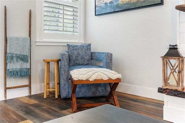 living area featuring baseboards and wood finished floors