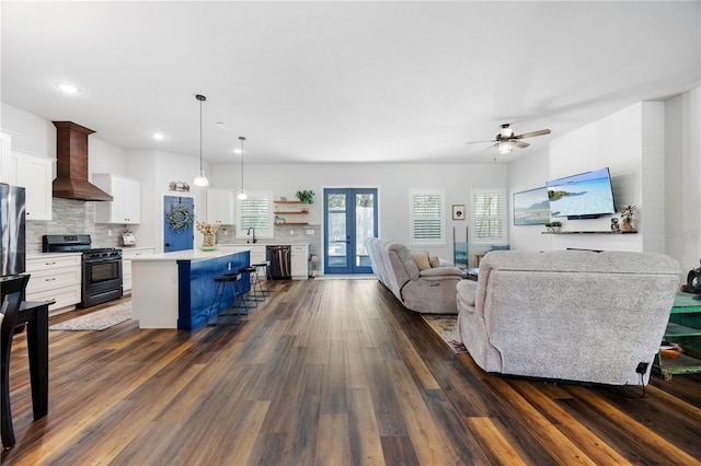 living area with a ceiling fan, recessed lighting, french doors, and dark wood finished floors