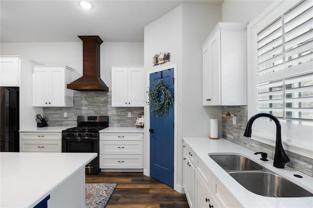 kitchen with custom range hood, dark wood-type flooring, light countertops, black appliances, and a sink