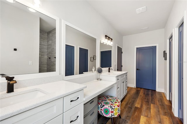 bathroom featuring hardwood / wood-style flooring, baseboards, and vanity