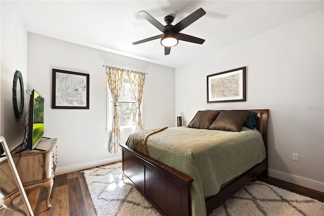 bedroom with a ceiling fan, baseboards, and wood finished floors