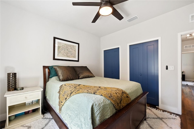 bedroom with a ceiling fan, baseboards, visible vents, and wood finished floors