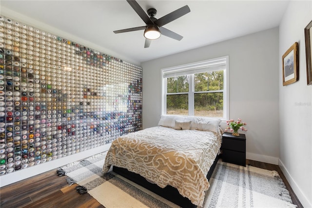 bedroom with a ceiling fan, baseboards, and wood finished floors