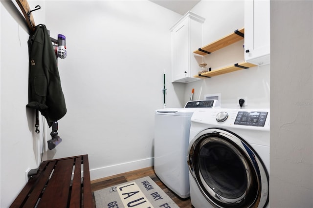 laundry area with washing machine and dryer, cabinet space, baseboards, and wood finished floors