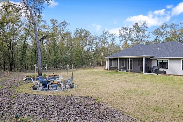 view of yard featuring a fire pit and a sunroom