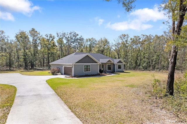 view of front of home featuring concrete driveway, an attached garage, board and batten siding, a view of trees, and a front lawn