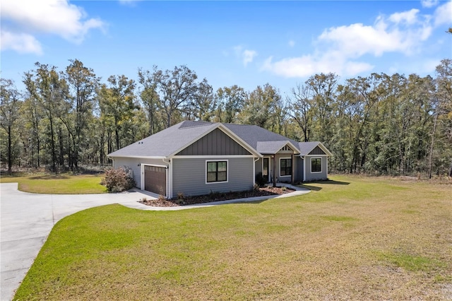 view of front of house with board and batten siding, a front yard, concrete driveway, and a garage