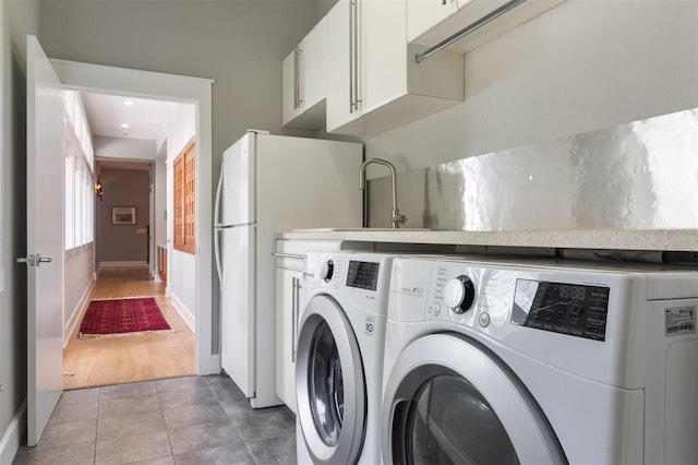 laundry area with baseboards, independent washer and dryer, and tile patterned floors