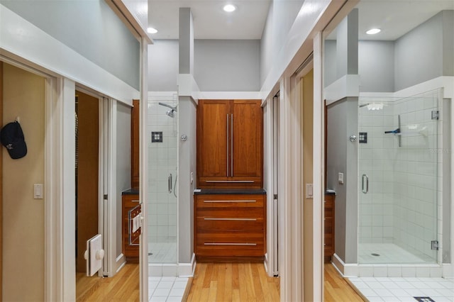 bathroom featuring a shower stall, wood finished floors, and recessed lighting