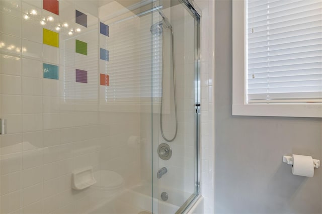 bathroom featuring combined bath / shower with glass door