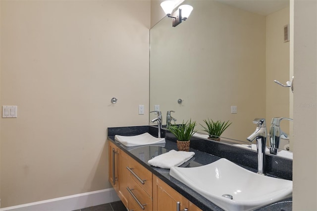 bathroom featuring visible vents, a sink, baseboards, and double vanity