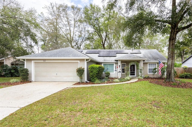 ranch-style home featuring a front lawn, fence, concrete driveway, roof mounted solar panels, and an attached garage