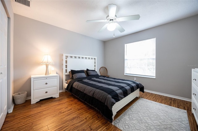 bedroom featuring visible vents, baseboards, wood finished floors, and a ceiling fan