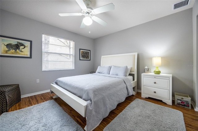 bedroom featuring visible vents, baseboards, ceiling fan, and dark wood-style flooring