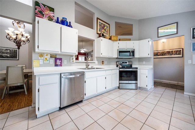 kitchen featuring a sink, appliances with stainless steel finishes, white cabinets, light countertops, and light tile patterned floors