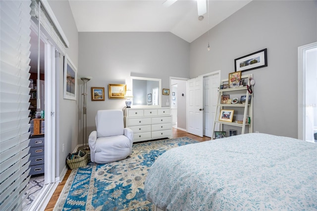 bedroom featuring lofted ceiling, wood finished floors, baseboards, and ceiling fan