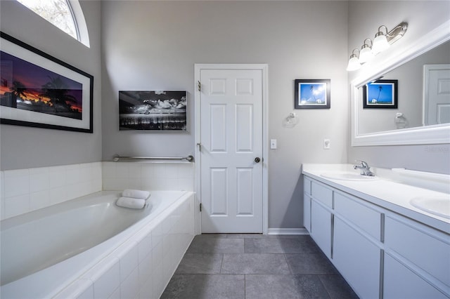 bathroom featuring double vanity, a garden tub, and a sink