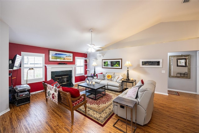 living area featuring a high end fireplace, baseboards, lofted ceiling, and wood finished floors