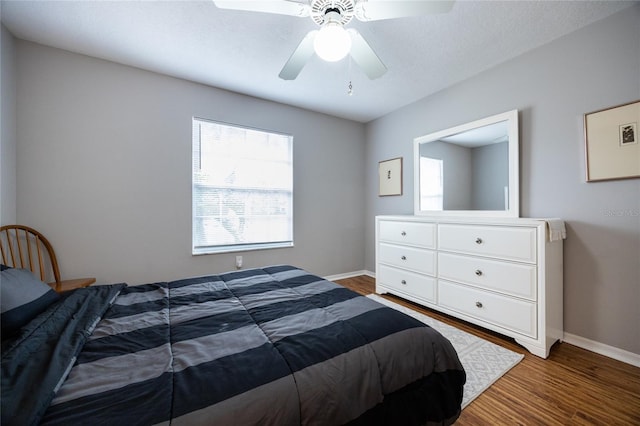 bedroom with wood finished floors, baseboards, and ceiling fan