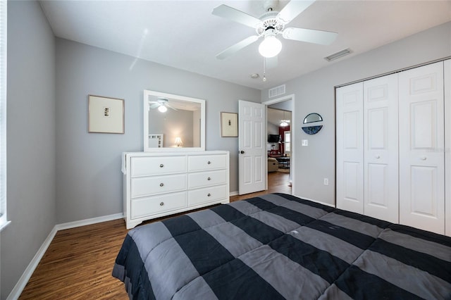 bedroom with a closet, baseboards, visible vents, and dark wood-style flooring