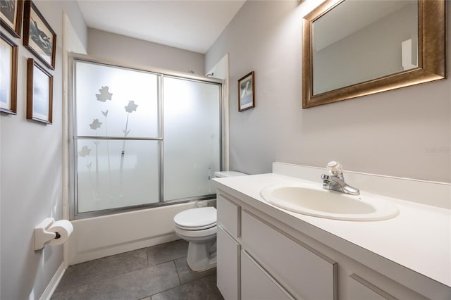 bathroom featuring tile patterned floors, toilet, vanity, and bath / shower combo with glass door