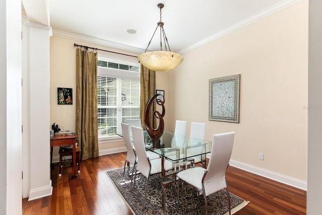 dining room featuring baseboards, hardwood / wood-style flooring, and crown molding