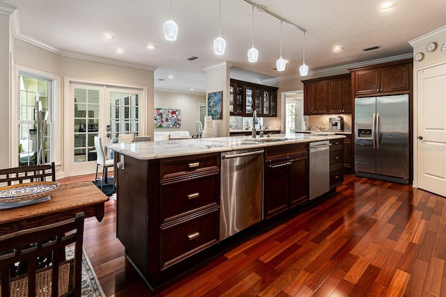 kitchen with dark brown cabinetry, dark wood finished floors, an island with sink, appliances with stainless steel finishes, and french doors