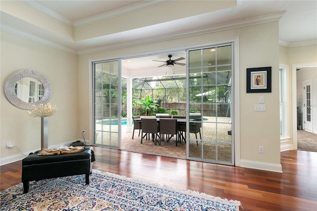 entryway with baseboards, a sunroom, ceiling fan, ornamental molding, and wood finished floors