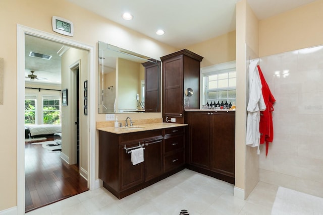 ensuite bathroom featuring a wealth of natural light, vanity, visible vents, and recessed lighting