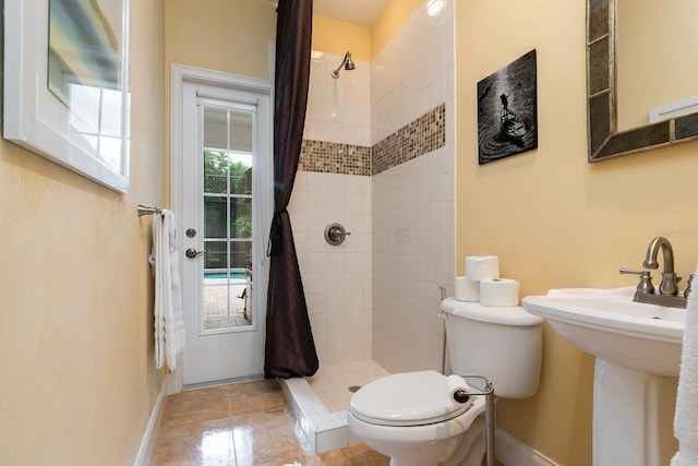 full bath featuring toilet, a shower stall, and baseboards