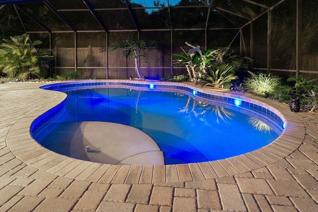 pool with a lanai, a patio area, and fence