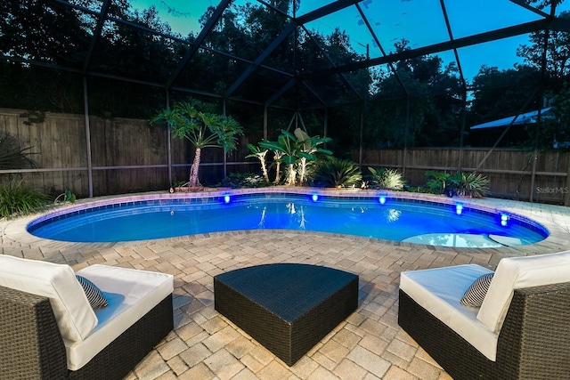 view of swimming pool featuring a fenced in pool, glass enclosure, a patio area, and a fenced backyard