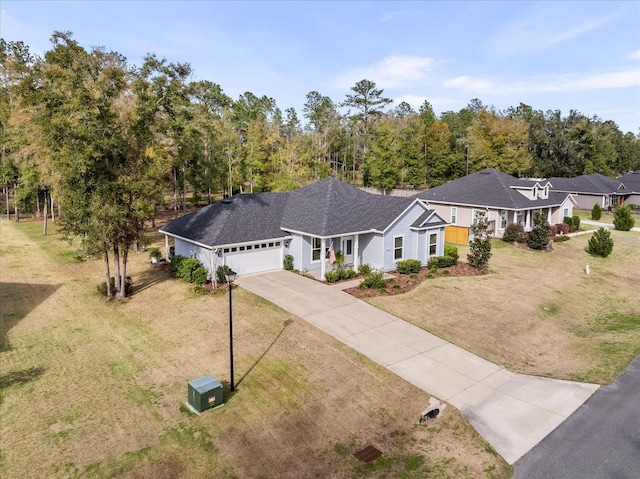 view of front of home featuring concrete driveway, an attached garage, roof with shingles, and a front lawn