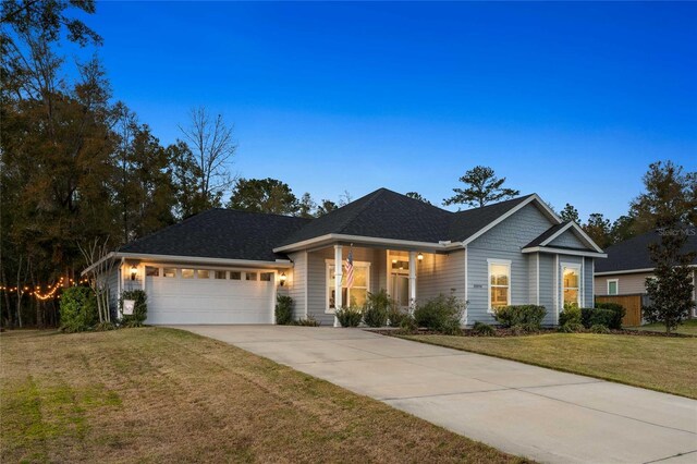 view of front of house with an attached garage, a porch, a front yard, and concrete driveway