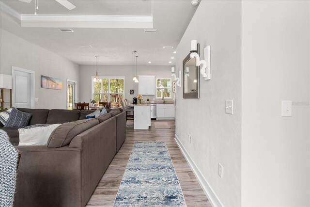 living room with baseboards, ceiling fan, light wood-style flooring, and visible vents