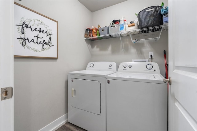 laundry room featuring baseboards, laundry area, washing machine and dryer, and wood finished floors