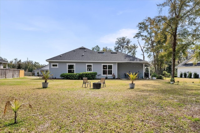 rear view of property with a yard, central AC, and an outdoor fire pit
