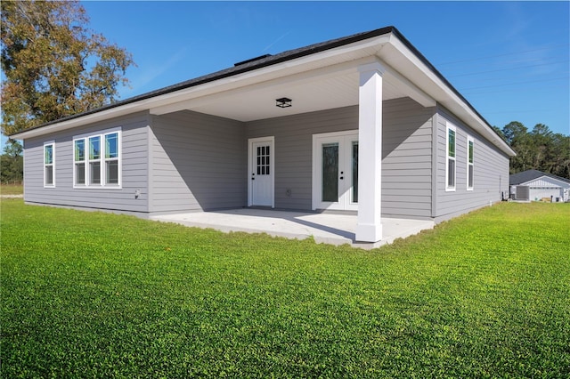 rear view of house with a patio area, french doors, and a yard