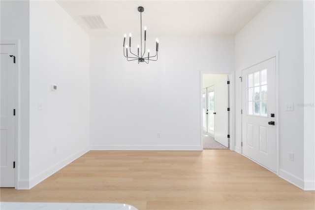 unfurnished dining area with baseboards, visible vents, and light wood finished floors