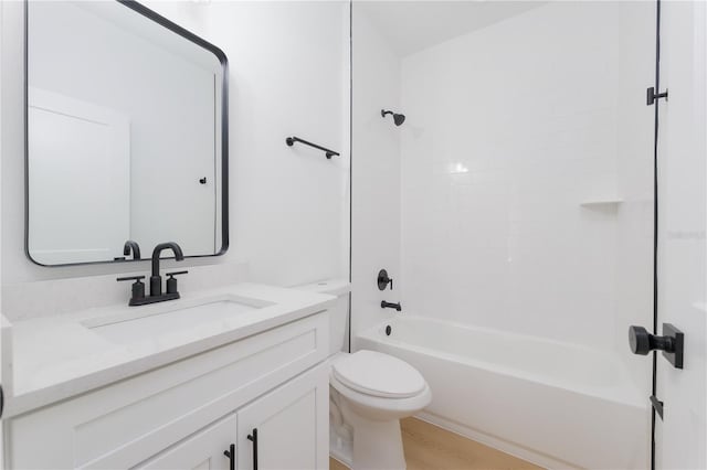 bathroom featuring toilet, tub / shower combination, wood finished floors, and vanity