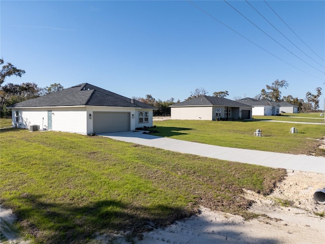 exterior space featuring concrete driveway, a front lawn, an attached garage, and cooling unit