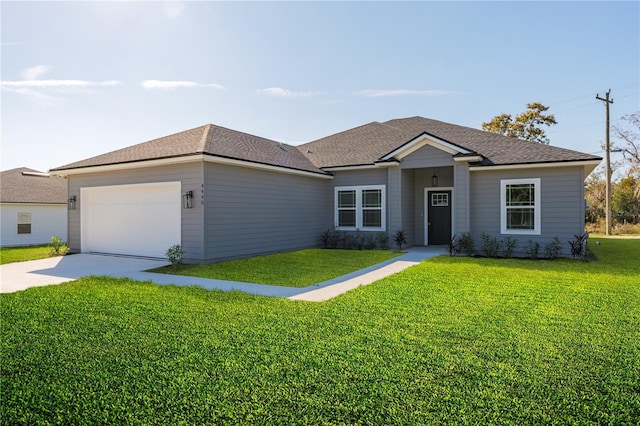 ranch-style home featuring an attached garage, roof with shingles, concrete driveway, and a front yard