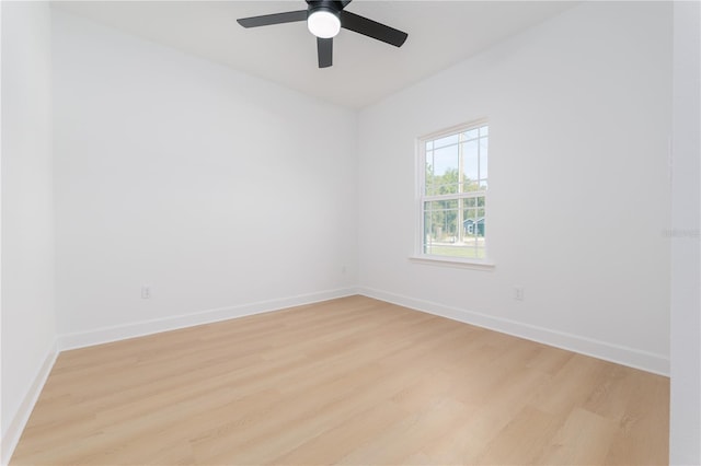 empty room with light wood-style flooring, baseboards, and a ceiling fan