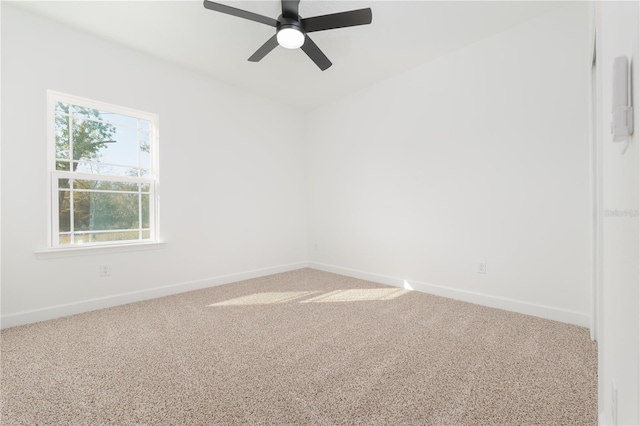 empty room with carpet floors, baseboards, and a ceiling fan