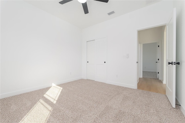 unfurnished bedroom featuring baseboards, carpet, visible vents, and a closet